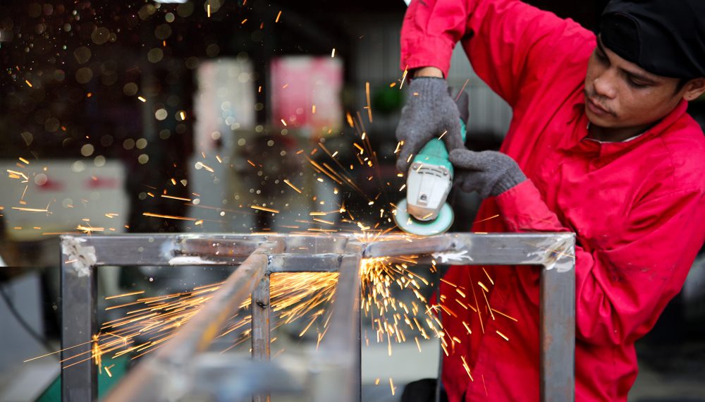 Factory worker grinding a metal,close up worker Metal shop welding girding in progress